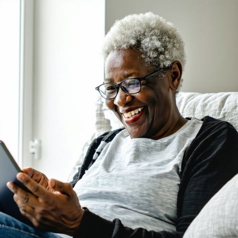Happy reassured patient at home using a tablet or laptop to view an online medical statement bright natural light modern and tidy home setting peaceful mood-2